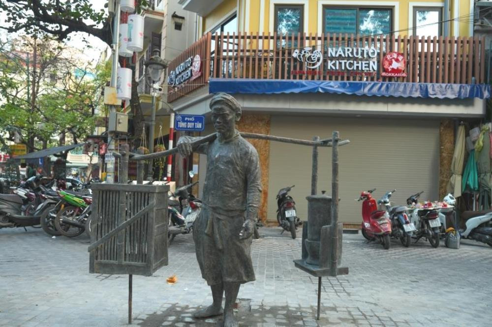 La sculpture originale « Phở gánh » du peintre The Son et du sculpteur Tran Quoc Thinh installée dans la rue gastronomique Duy Tân à Hanoï. Photo : kinhtedothi. La sculpture originale « Phở gánh » du peintre The Son et du sculpteur Tran Quoc Thinh installée dans la rue gastronomique Duy Tân à Hanoï. Photo : kinhtedothi.