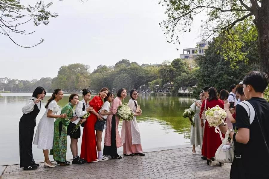 Des touristes posent pour des photos sur les rives du lac Hoan Kiem. Photo : Xinhua. Des touristes posent pour des photos sur les rives du lac Hoan Kiem. Photo : Xinhua.