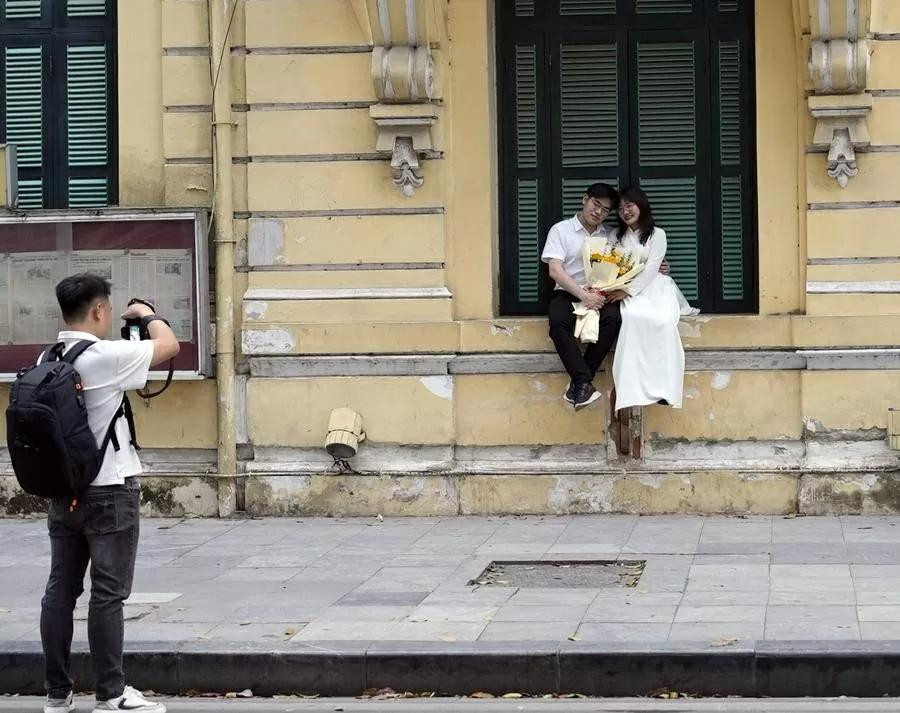 Le couple pose pour des photos dans une rue de Hanoï. Photo : Xinhua. Le couple pose pour des photos dans une rue de Hanoï. Photo : Xinhua.