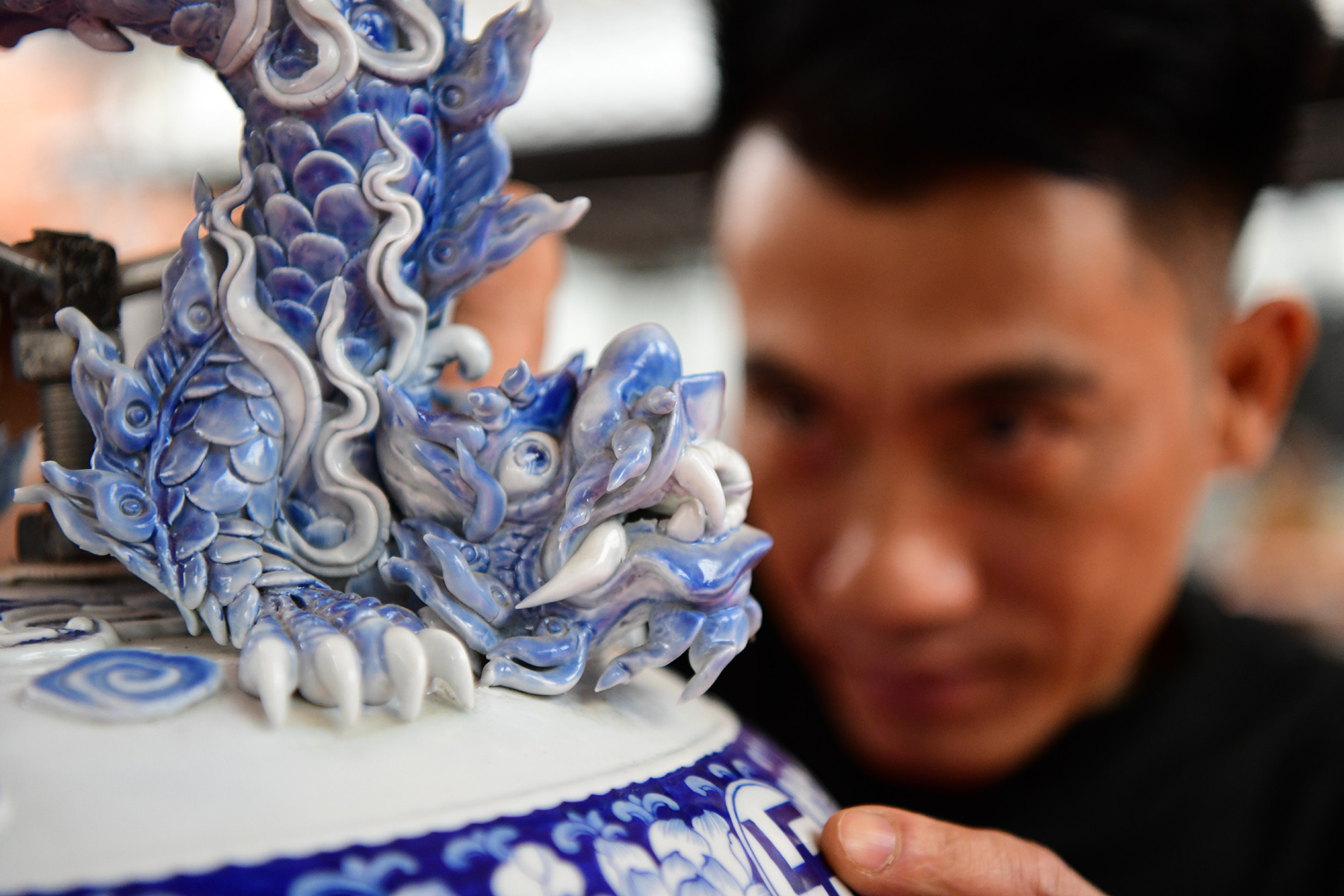 L'artisan Dao Viet Binh présente son chef-d'œuvre "Héros de Dien Bien" (diamètre de 1,65 m, haut de 1,1 m), une œuvre céramique illustrant la grandeur épique de l'histoire nationale. Photo : Thê Duong.