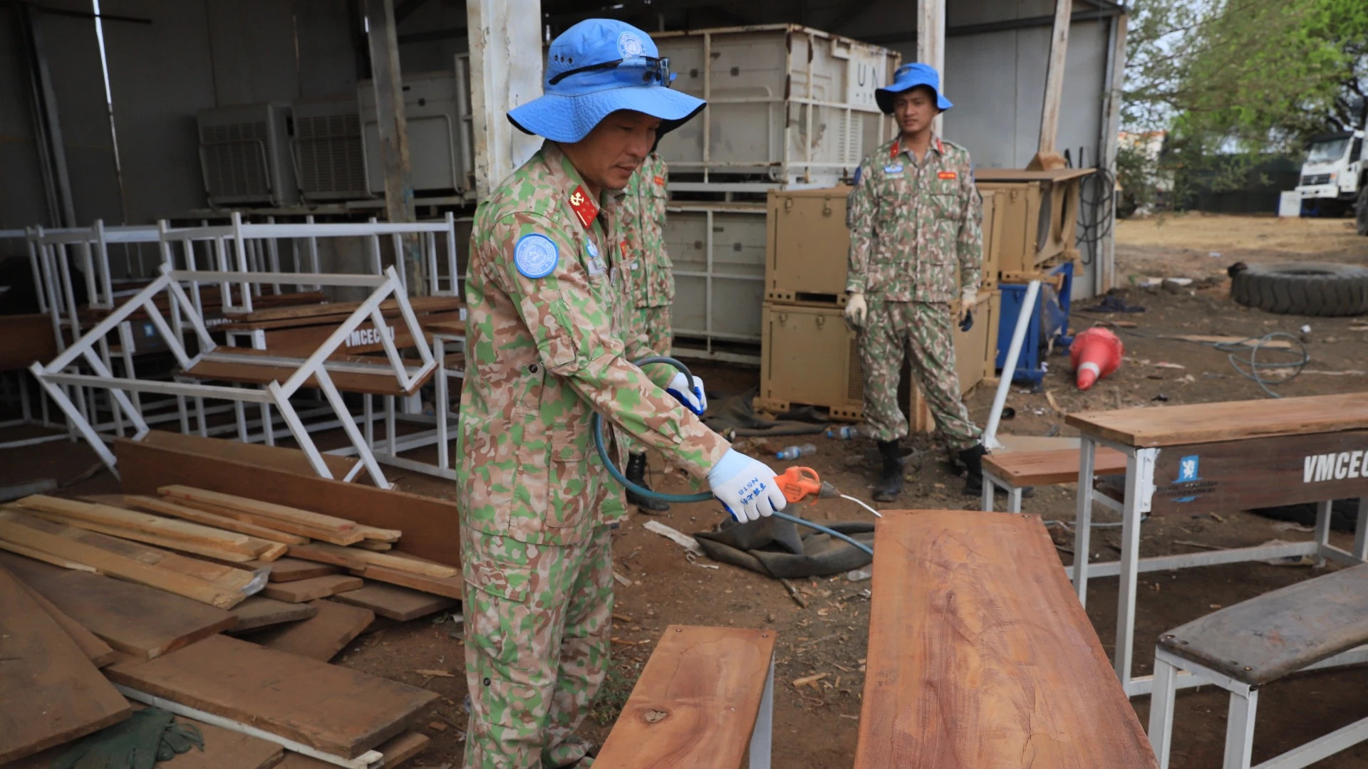 Le personnel de la 2e sous-unité de construction du génie militaire n° 3 fabrique des tables-bancs à partir de matériaux récupérés.