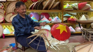 L’artisan Le Van Tuy détache avec minutie les cercles de bambou servant à la confection des chapeaux.