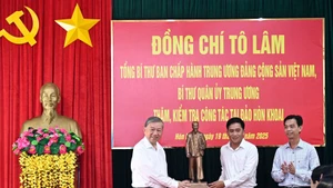 Le secrétaire général du Parti To Lam (gauche) offre une statue de l'Oncle Hô à des responsables de la commune de Dat Mui, province de Ca Mau. Photo : VNA. 