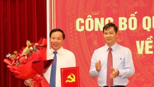 Nguyen Thanh Tam, membre du Comité central du Parti et vice-chef de la Commission d’organisation du Comité central, remet la décision du Secrétariat à Nguyen Van Ut. Photo: VNA 