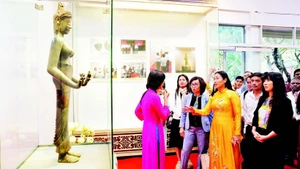 Des visiteurs admirent l’originale de la statue du Bodhisattva Tara, classée trésor national, dans l’espace d’exposition « Trésors nationaux – Un patrimoine au cœur de Da Nang ».
