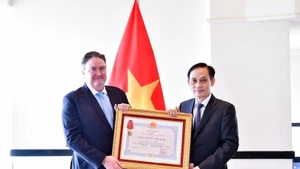 Le ministre des Affaires étrangères, Le Hoai Trung (droite), remet l’Ordre de l’Amitié à l’ambassadeur américain Marc Knapper. Photo : VNA. 