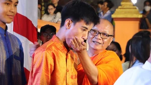 Rite du nourrissage au riz plat (cốm dẹp, sorte de jeune riz gluant aplati) lors de la fête de la Lune. Photo : VNA 