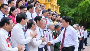 Le président Luong Cuong (à droite) serre la main des journalistes chevronnés, à Hanoi, le 20 juin. 