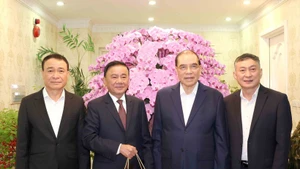 Tran Cam Tu (2e à partir de la gauche), permanent du Secrétariat du Comité central du Parti, rend visite à l’ancien secrétaire général du Parti Nong Duc Manh (3e à partir de la gauche). Photo: VNA 