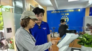 Des habitants effectuent des opérations sur un robot d’IA assistant les démarches administratives au quartier de Cua Nam. Photo d’illustration : VNA. 
