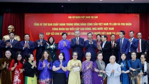 Le secrétaire général du PCV To Lam rencontre la communauté vietnamienne au Laos. Photo : VNA 