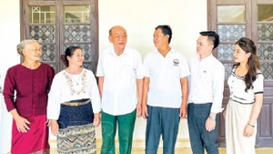 Le président de l’Association d’amitié Vietnam - Laos de la province de Thai Binh, Nguyen Duc Hanh (troisième à partir de la gauche), et la famille de deux filleuls laotiens. Photo : Journal de Thai Binh.