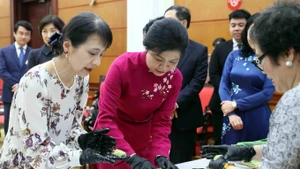 Les épouses de dirigeants vietnamien et japonais préparent du "bánh cốm". Photo : VNA.