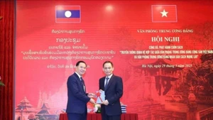 Le Hoai Trung (droite), secrétaire du Comité central du PCV et chef du Bureau du Comité central du PCV, offre un exemplaire du livre à Thongsalith Mangnomek, secrétaire du Comité central du PPRL et chef du Bureau du Comité central du PPRL. Photo : VNA.