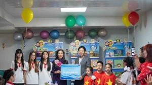 Madame Ngo Phuong Ly offre une bibliothèque de livres vietnamiens à la classe. Photo : NDEL