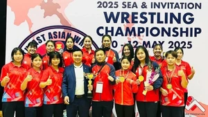 Les membres de l’équipe nationale de lutte du Vietnam posent avec la coupe du vainqueur par équipes. Photo : NDEL.
