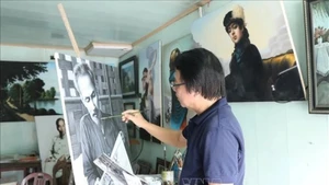 L'artiste Tran Hoa Binh peint le portrait de l'Oncle Ho. Photo : VNA.