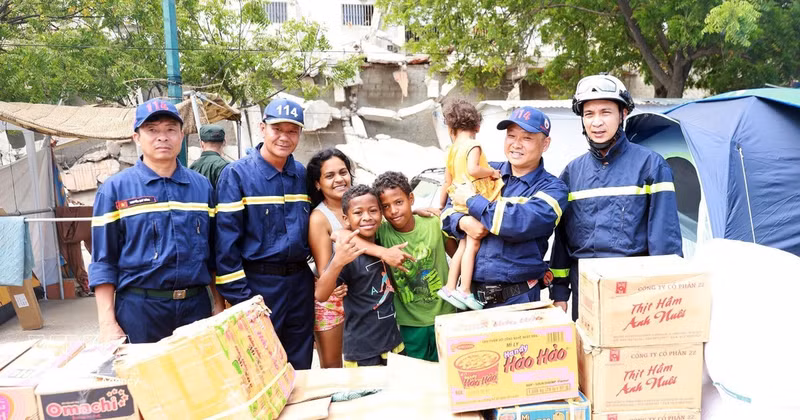 Distribution de produits de première nécessité et de denrées alimentaires dans le campement provisoire des victimes des séismes. Photo : VNA. 