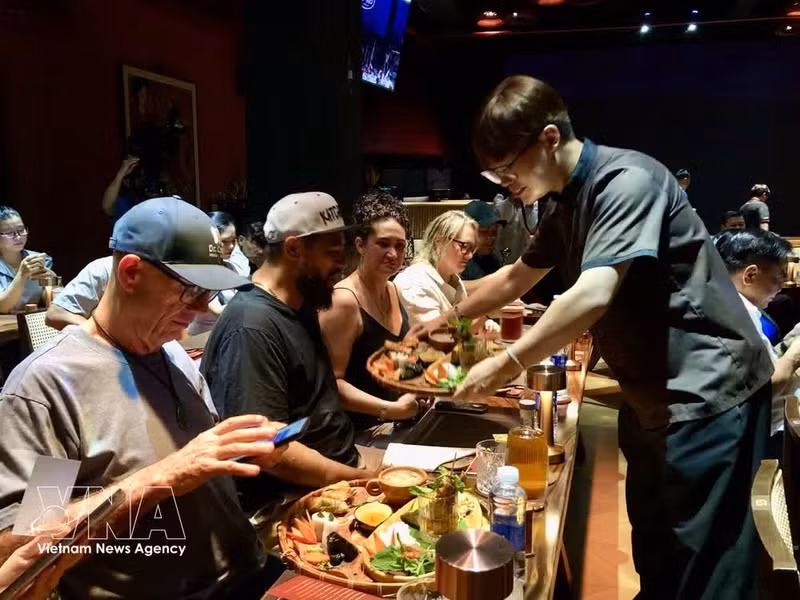 Des touristes étrangers sont séduits par les particularités de la cuisine vietnamienne. Photo : VNA.