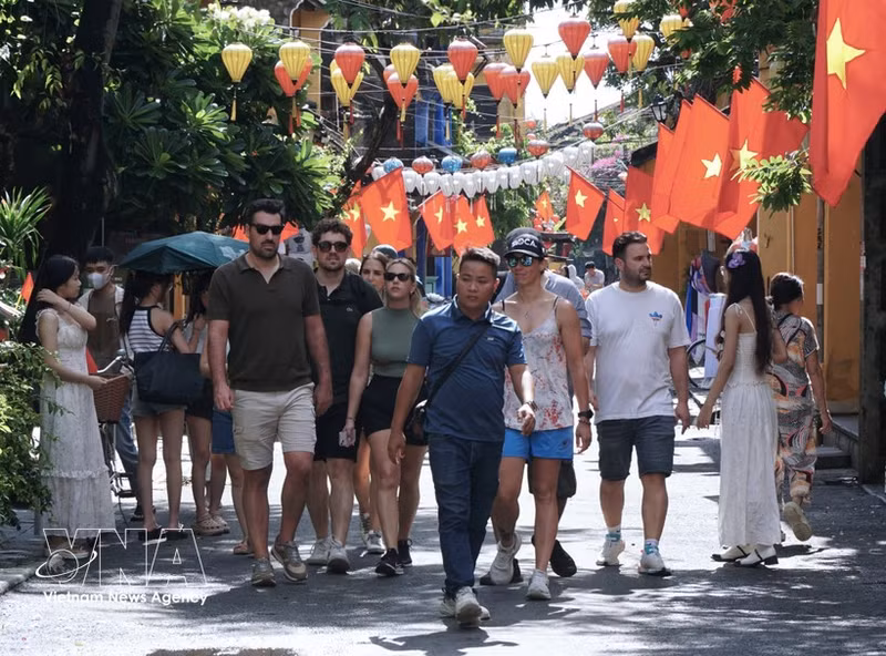 Des touristes étrangers visitent Hoi An. Photo : VNA. 