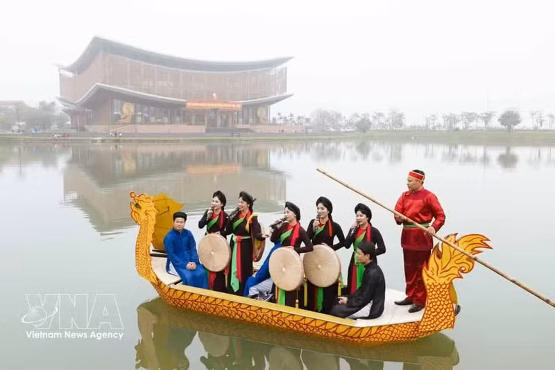 Des chanteurs et chanteuses de chant alterné (Quan ho) interprètent des chants traditionnels et échangent avec le public à bord d’une embarcation. Photo : VNA. 