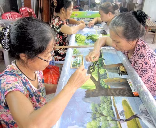 Les brodeuses du village de Minh Lang réalisent avec minutie une fresque paysagère. Photo : VOV2. 