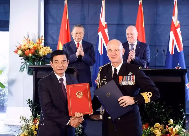 Le secrétaire général et président Tô Lâm (à gauche, deuxième plan) et le Premier ministre néo-zélandais Christopher Luxon supervisent l’échange de documents de coopération entre le Vietnam et la Nouvelle-Zélande. Photo : VNA. 