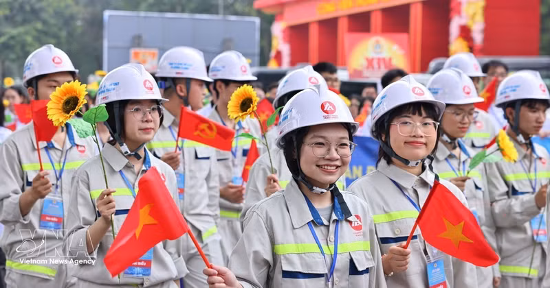 Des travailleurs participent au grand défilé pour la Journée internationale du Travail. Photo: VNA 