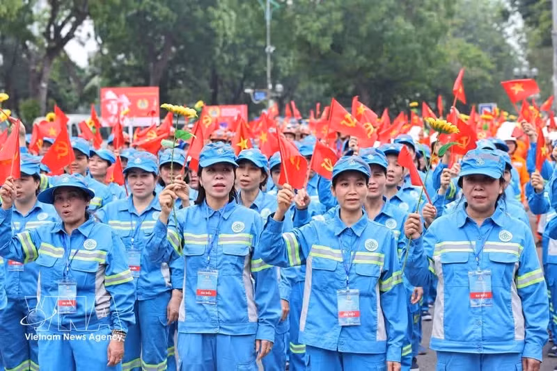 Des travailleurs participent au grand défilé pour la Journée internationale du Travail. Photo: VNA