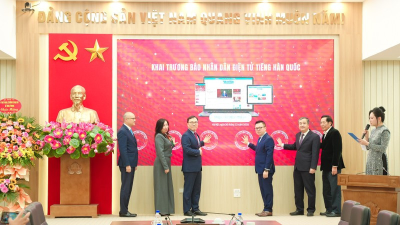 Les délégués appuient sur le bouton pour lancer la version en ligne en langue coréenne du journal Nhan Dan. Photo : TIEN DAT 