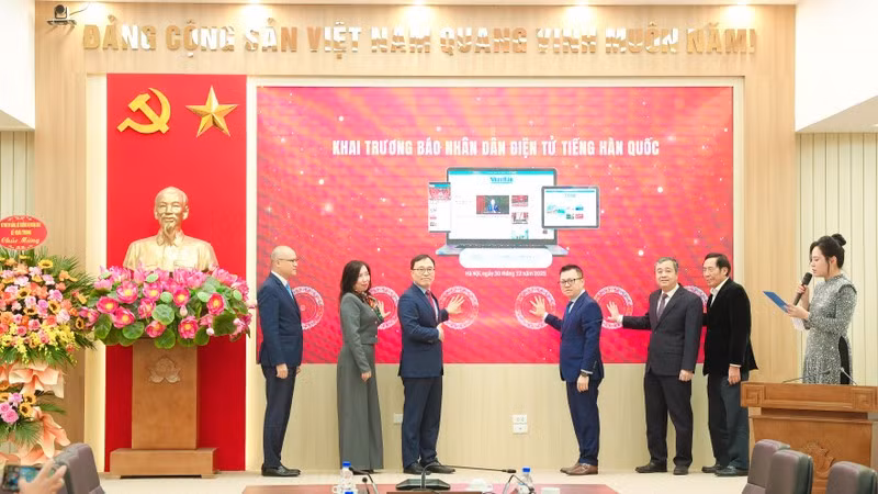 Les délégués appuient sur le bouton pour lancer la version en ligne en langue coréenne du journal Nhan Dan. Photo : TIEN DAT 