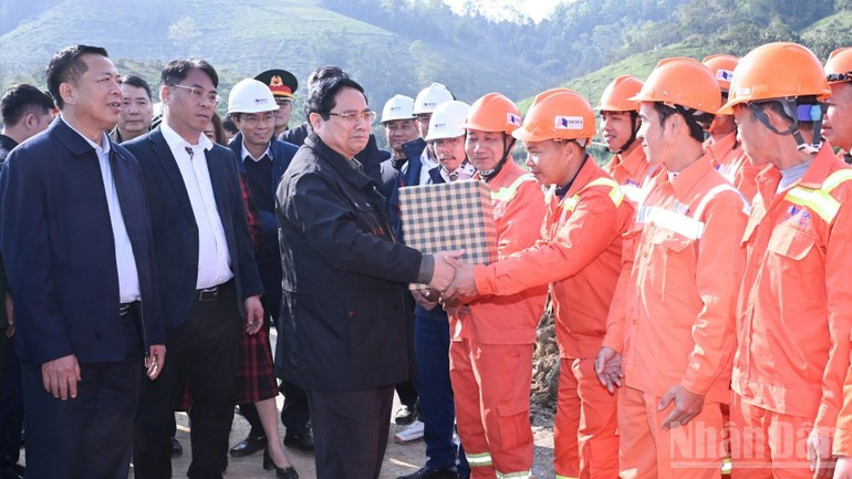 Le Premier ministre Pham Minh Chinh présente ses vœux du Nouvel An aux ouvriers travaillant sur le chantier de l’autoroute Dong Dang – Tra Linh. Photo : VNA. 