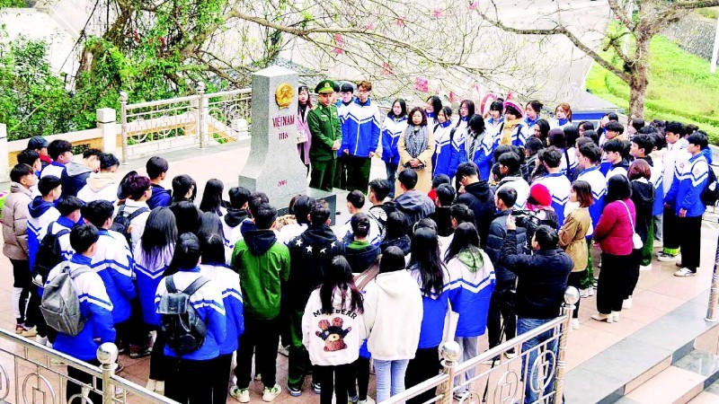 Des élèves du lycée de Dong Dang écoutent un garde-frontière du poste de Huu Nghi présenter la borne frontalière n°1116.