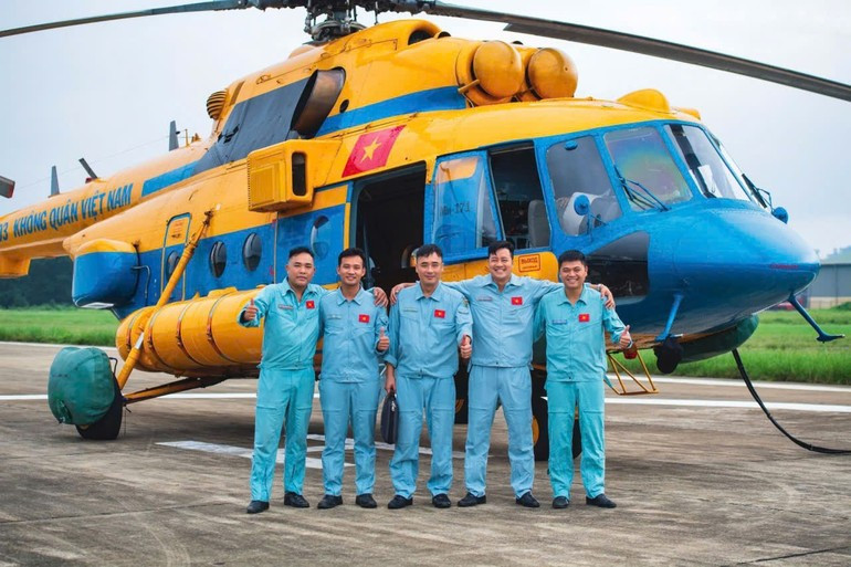 L’équipage de l’hélicoptère Mi‑171, immatriculé SAR‑03, pose pour une photo souvenir après avoir accompli avec succès une mission de transport d’aide humanitaire à destination des populations sinistrées des inondations à Nghệ An et dans les provinces montagneuses du nord du Vietnam. Photo : Thai Hieu