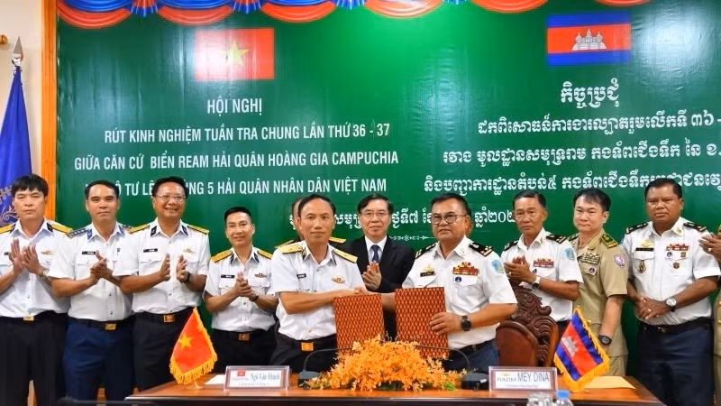 Le contre-amiral Ngo Van Thanh, commissaire politique du Commandement de la 5ᵉ Région navale, et le vice-amiral May Dina, commandant de la base navale de Ream, échangent le mémorandum de coopération. (Photo : TRAN KIEN)