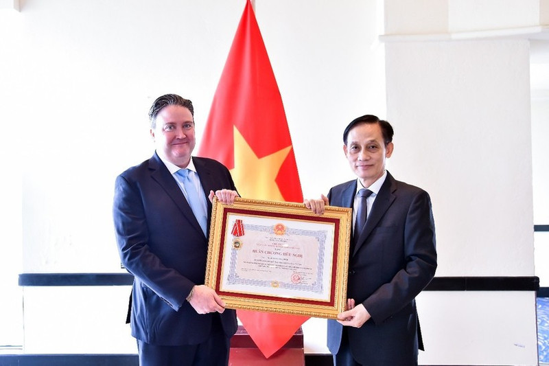 Le ministre des Affaires étrangères, Le Hoai Trung (droite), remet l’Ordre de l’Amitié à l’ambassadeur américain Marc Knapper. Photo : VNA. 
