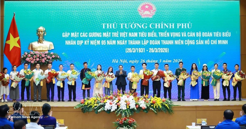 Le Premier ministre Pham Minh Chinh offre des fleurs de félicitations aux jeunes Vietnamiens exemplaires. Photo : VNA. 