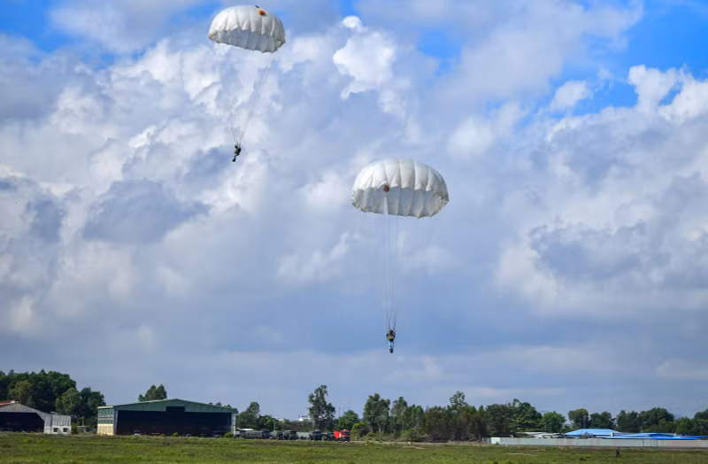 Les parachutistes dirigent leur voile vers les zones d’atterrissage prévues.