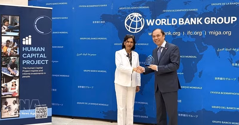La vice-présidente du Groupe de la Banque mondiale pour les Ressources humaines, Radi Anguelova, remet le titre à l’ambassadeur du Vietnam aux États-Unis, Nguyên Quôc Dung. Photo : VNA 
