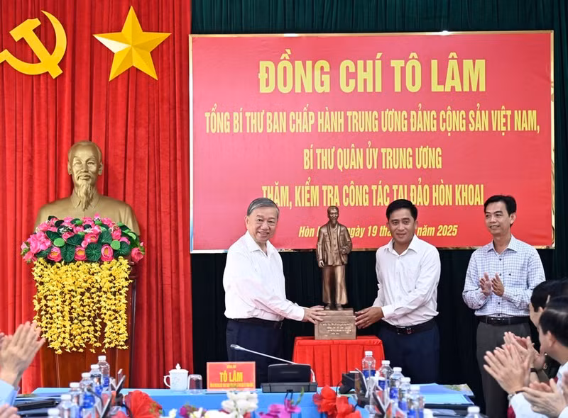 Le secrétaire général du Parti To Lam (gauche) offre une statue de l'Oncle Hô à des responsables de la commune de Dat Mui, province de Ca Mau. Photo : VNA. 