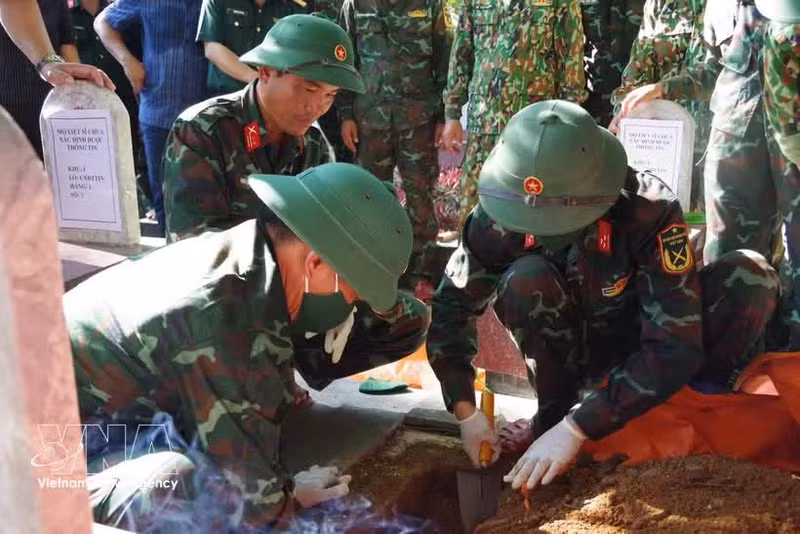 Des soldats prélèvent des échantillons de restes de soldats tombés au champ d'honneur au cimetière national des martyrs de Truong Son. Photo : VNA