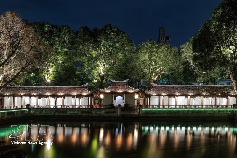 Effets lumineux projetés sur la surface des stèles en pierre et les motifs anciens, mettant en valeur les détails du patrimoine. Photo : VNA.
