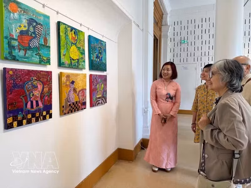 Des visiteurs contemplent des oeuvres exposées. Photo: VNA