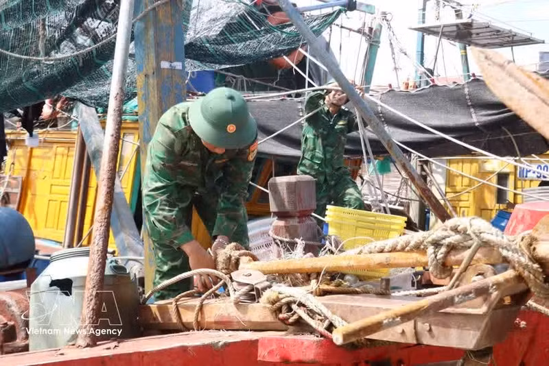 Des gardes-frontières aident les pêcheurs à éviter le typhon MAYSAK. Photo : VNA.