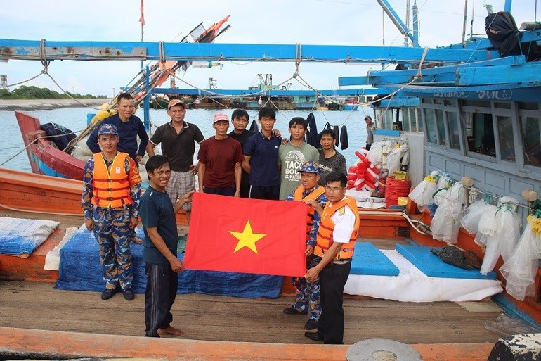 Des officiers de l'île de Song Tu Tay offrent des cadeaux et de la nourriture aux pêcheurs venus se réfugier sur l'île pour échapper à la tempête. Photo : NDEL.