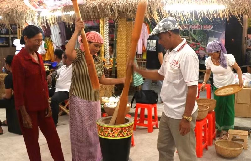 Des touristes découvrent la fabrication traditionnelle du cốm dẹp chez les Khmers de Soc Trang, aujourd’hui Can Tho. Photo : laodong.vn