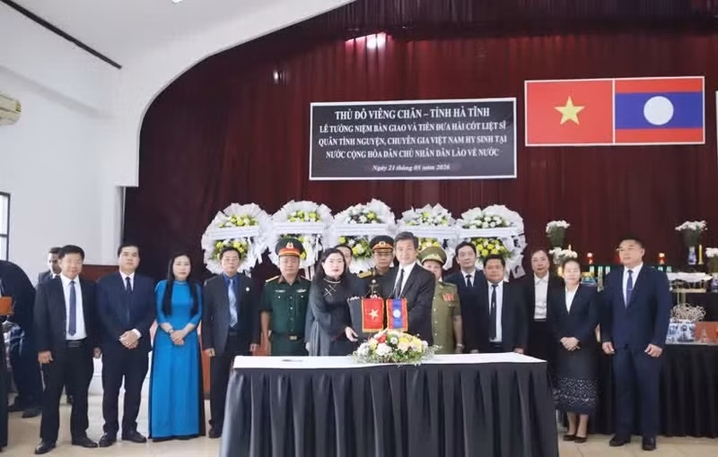 Le Comité spécial de la capitale Vientiane et le Comité spécial de la province de Ha Tinh procèdent à la remise du procès-verbal de transfert des restes des martyrs. Photo : VNA