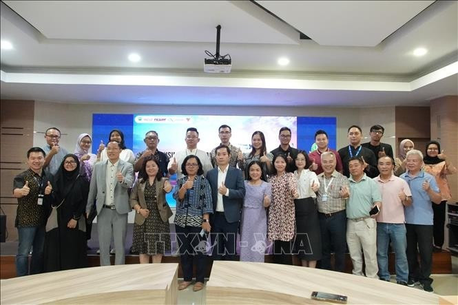 Des représentants d'entreprises vietnamiennes et indonésiennes prennent une photo souvenir avec les organisateurs du forum. Photo : VNA.