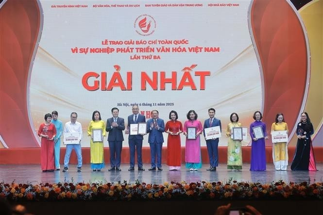 Le vice-Premier ministre Mai Van Chinh (4e, gauche) et le ministre de la Culture, des Sports et du Tourisme, Nguyen Van Hung (6e, gauche), remettent le premier prix aux auteurs et aux groupes d'auteurs lauréats. Photo : VNA.
