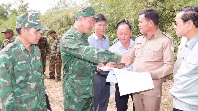 Les autorités vietnamiennes et cambodgiennes échangent des informations sur une carte. Photo : NDEL